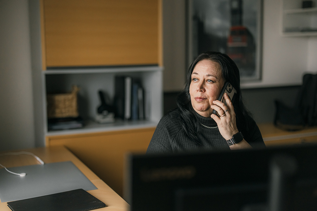 Henkilöstösihteeri Eija Osmo puhuu puhelimessa.